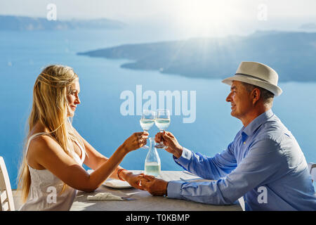 Adult couple having dinner and drinking wine in a restaurant on the background of the sea Stock Photo