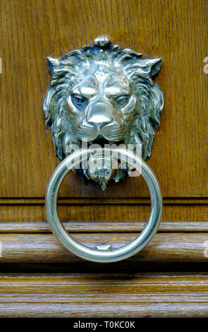 Close up of a silver lion head door knock  on a wooden heavy door in Paris, France Stock Photo