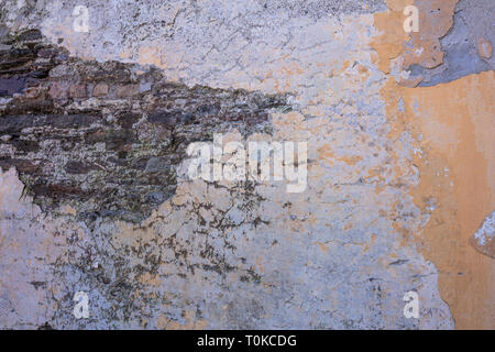 Old, distressed stone wall, building facade. Painted orange color, faded masonry texture background Stock Photo
