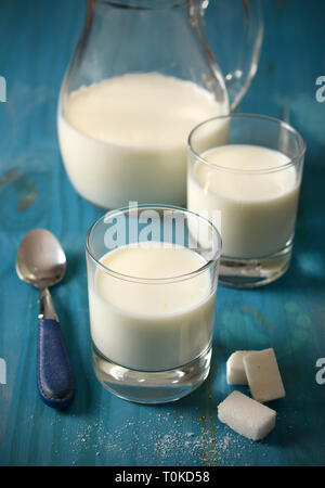 fresh milk in glasses with sugar cubes - closeup Stock Photo