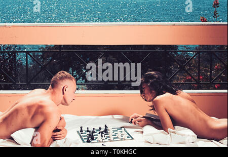young couple playing chess while relax on balcony. Stock Photo