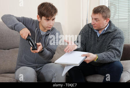 Father requires his son to finish playing computer games Stock Photo