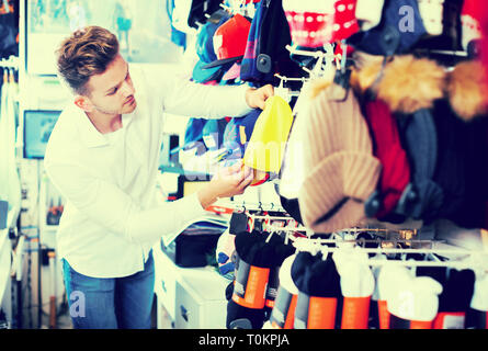 Man choosing new knit cap in sports store Stock Photo
