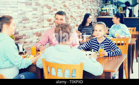 Glad family with teenagers having lunch in cozy cafe Stock Photo
