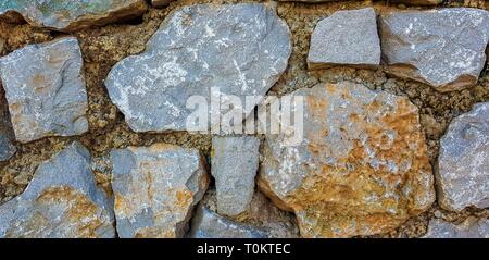 Stone wall rustic texture background. Textured stone wall closeup. Stock Photo