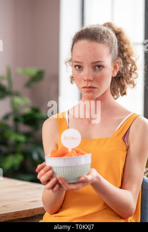 Upset good-looking woman with light eyes having allergy on fruits in bowl Stock Photo