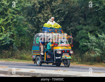 AGRA, INDIA - NOVEMBER 15, 2012: Traffic on the streets of India. Large Indian families travel in one small car. Indian people and their colorful cult Stock Photo