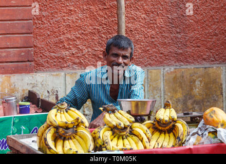 AGRA, INDIA - NOVEMBER 16, 2012: Indian man in the market sells bananas Stock Photo