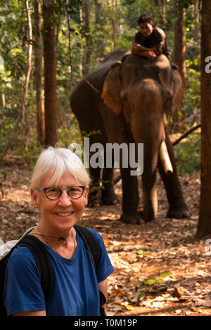 Cambodia, Mondulkiri Province, Sen Monorom, Elephant Valley Project, senior tourist posing for photograph with Hen, male former logging elephant walki Stock Photo