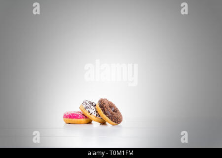 Chocolate, red, and white donuts on table and gray background Stock Photo