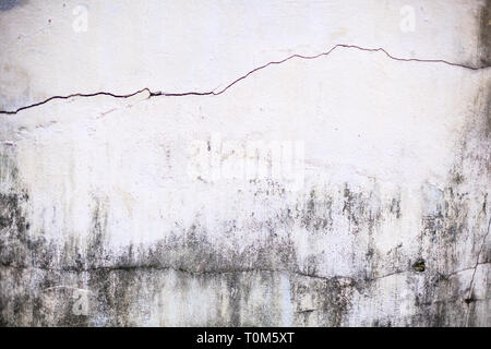 plain old aged white colored painted  faded weathered textured pattern on cracked cement concrete house wall surface background. Detailed backdrop, ab Stock Photo