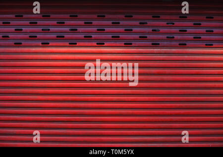old detailed aged vintage red textured zinc alloy metal roller shutter door, store front exterior design used in construction industry as building mat Stock Photo
