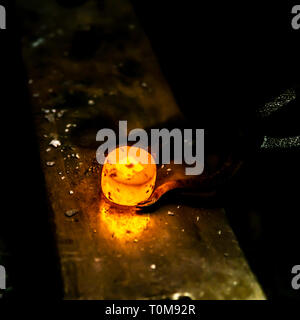 Hot und glow iron workpiece during work in a blacksmith. Stock Photo