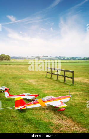 Model airplanes ona line on a green field in the summer under a blue sky Stock Photo
