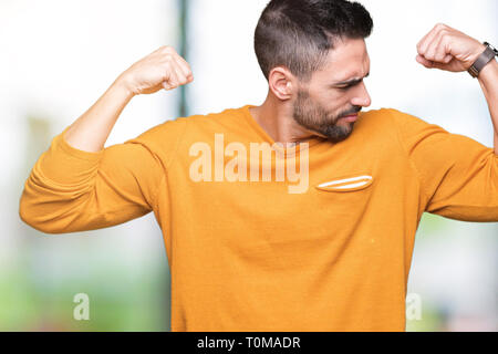 Young handsome man over isolated background showing arms muscles smiling proud. Fitness concept. Stock Photo