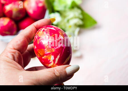 Female hand holding an Easter egg first person view Stock Photo