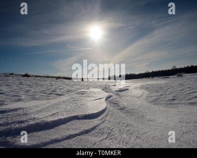 Melting Snow Spring Bokeh Snow. Shot against Setting Sun, wide open aperture. White snowflake background Stock Photo