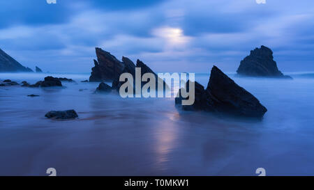 Moonlight on sandy beach with rock formations, Praia da Adraga, Sintra, Portugal Stock Photo