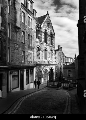 Two figures walking along Upper Bow off the Royal Mile in the Old Town in Edinburgh Scotland Stock Photo