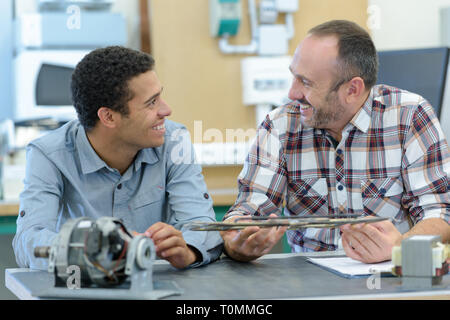 two positive workmen in workshop Stock Photo