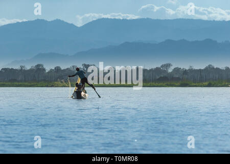 Traditional Fisherman in his boat holding the rudder with his feet Stock Photo