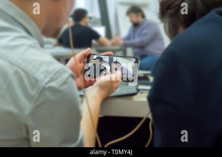 Monitoring education process with mobile phone. Record secretly on mobile phone. Mobile espionage. Hacker crack access code. Recording to a hidden Stock Photo