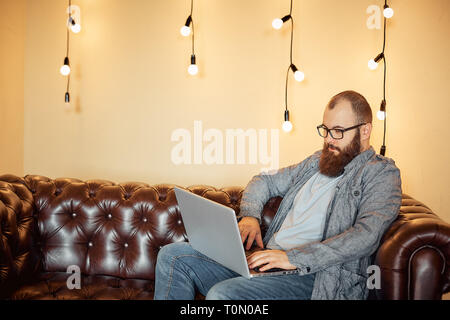 a successful man makes online transactions with the Bank on a laptop Stock Photo