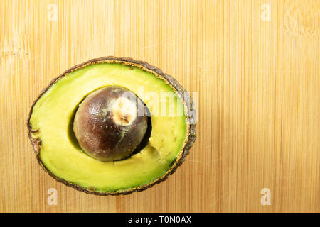 Avocado half sliced on wood background Stock Photo