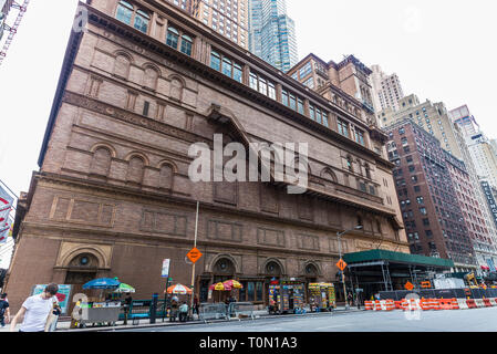 New York City, USA - July 28, 2018: Lateral facade with its staircase of the Carnegie Hall in 7th Avenue (Seventh Avenue) with people around in Midtow Stock Photo