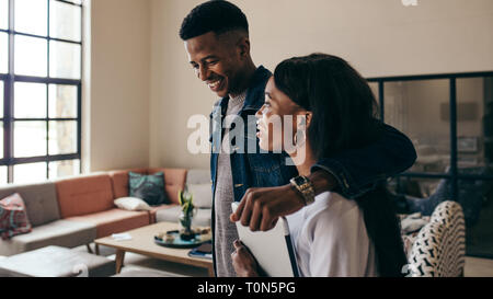 Two young college students walking together in lobby. Smiling young man walking with a girl at university campus. Stock Photo