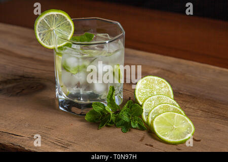 Mojito summer beach refreshing tropical cocktail in glass: soda water, lime juice, mint leaves, sugar, ice and rum. Fresh summer cocktail, sliced gree Stock Photo