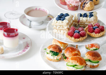 Afternoon tea with mini brioche canapes and selection of sweets Stock Photo