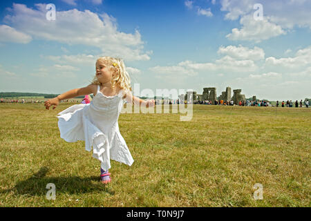 Europe, UK, England, Wiltshire. A 4 year old girl dances at Stonehenge. Stock Photo