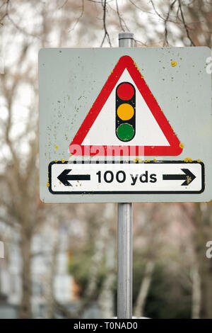 Triangular notice by the roadside advising of traffic lights in one hundred yards in both right and left directions. Stock Photo