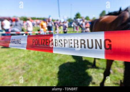 German police tape hangs on a crime scene. Polizeiabsprerrung means police cordon Stock Photo