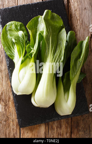 Healthy food baby bok choy chinese leaf cabbage on a slate board on the table. Vertical top view from above Stock Photo