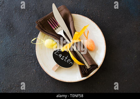 Festive table setting for holiday Easter dinner on dark table. Holidays background with copy space. Stock Photo