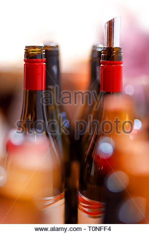 open wine bottles, flexible wine pourer, glasses, corks with blurred background at the wine tasting event Stock Photo