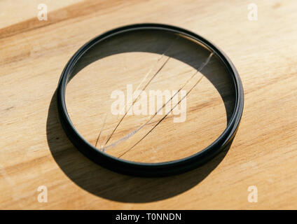 Broken photo-filter on wooden background. Stock Photo