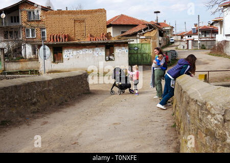 Turia, Bulgaria, March 9, 2019. There are masquerade games in the village to evict the evil. The masked are called Kukeri. Mother and her children exp Stock Photo