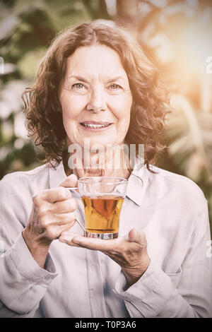 Smiling mature woman drinking herbal tea Stock Photo