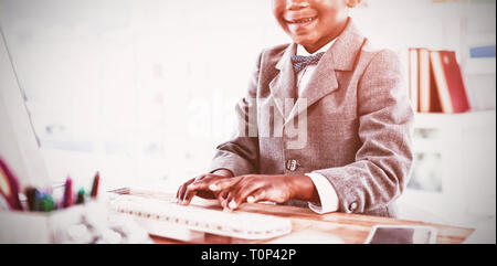 Portrait of boy imitating as businessman using computer Stock Photo