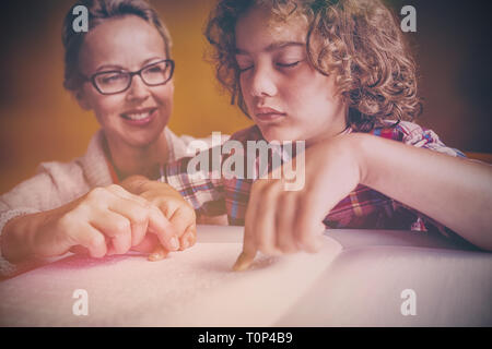 Teacher with boy using braille to read Stock Photo