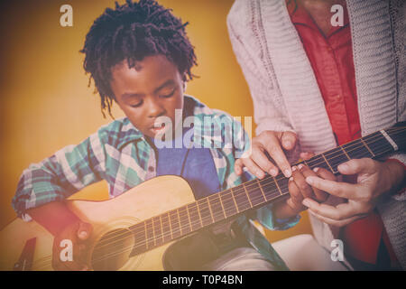 Boy learning to play guitar Stock Photo