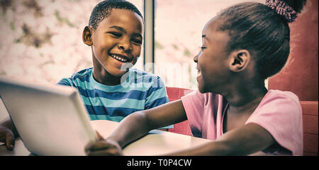 Children using digital tablet in classroom Stock Photo