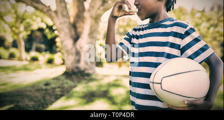 Boy using asthma inhaler in the park Stock Photo
