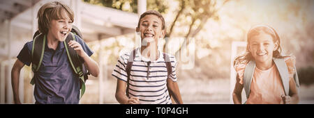 Happy school kids running in corridor Stock Photo