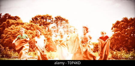 Children having a sack race in park Stock Photo