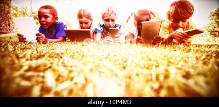 Kids using technology during a sunny day Stock Photo