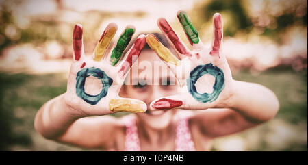Little girl making a triangle with her painted hands to the camera Stock Photo
